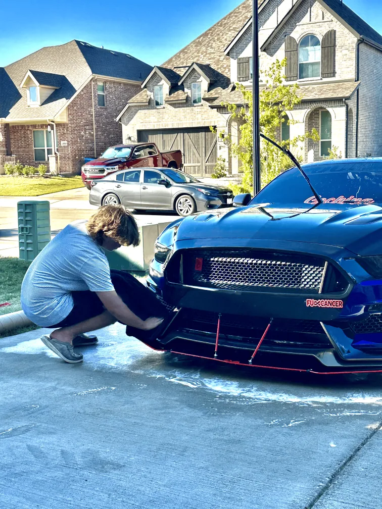 Cooper detailing the front of a blue Ford Mustang