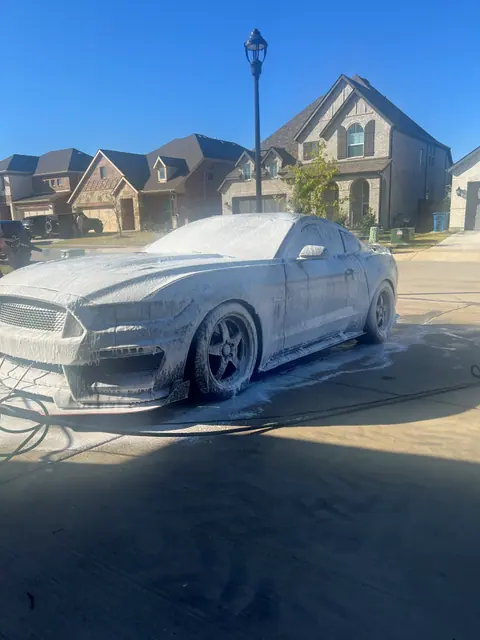 Blue Ford Mustang covered in foam during an exterior detail